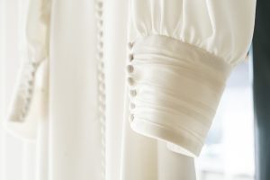 Manga del vestido de novia con encaje y botonadura clásica.
