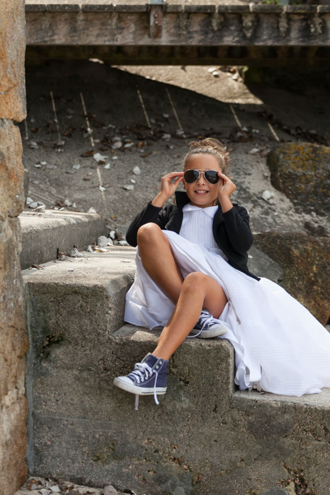 Sesión de comunión divertida y desenfadada en escaleras exteriores.