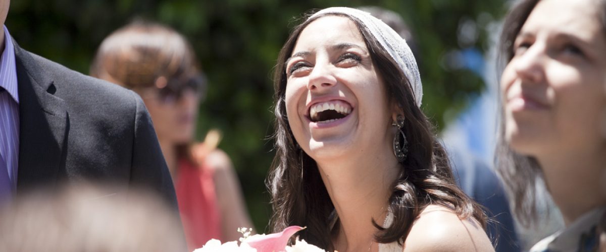 Novia riendo durante un momento espontáneo de la ceremonia de boda en Portugal.